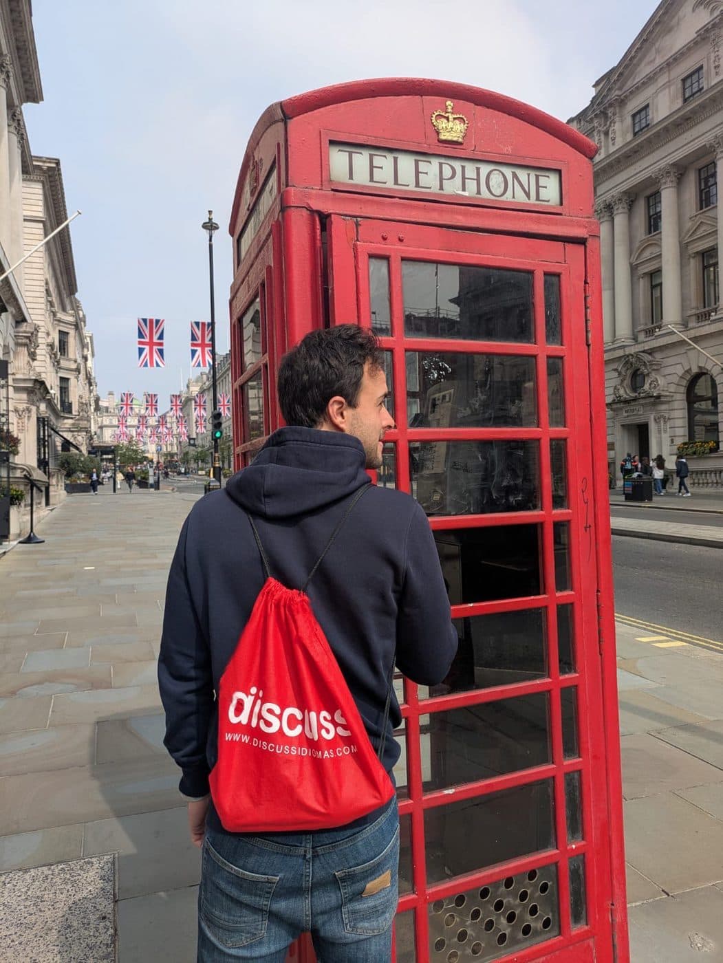 Cabina telefónica roja en Regent Street con banderas del Reino Unido colgadas sobre la calle